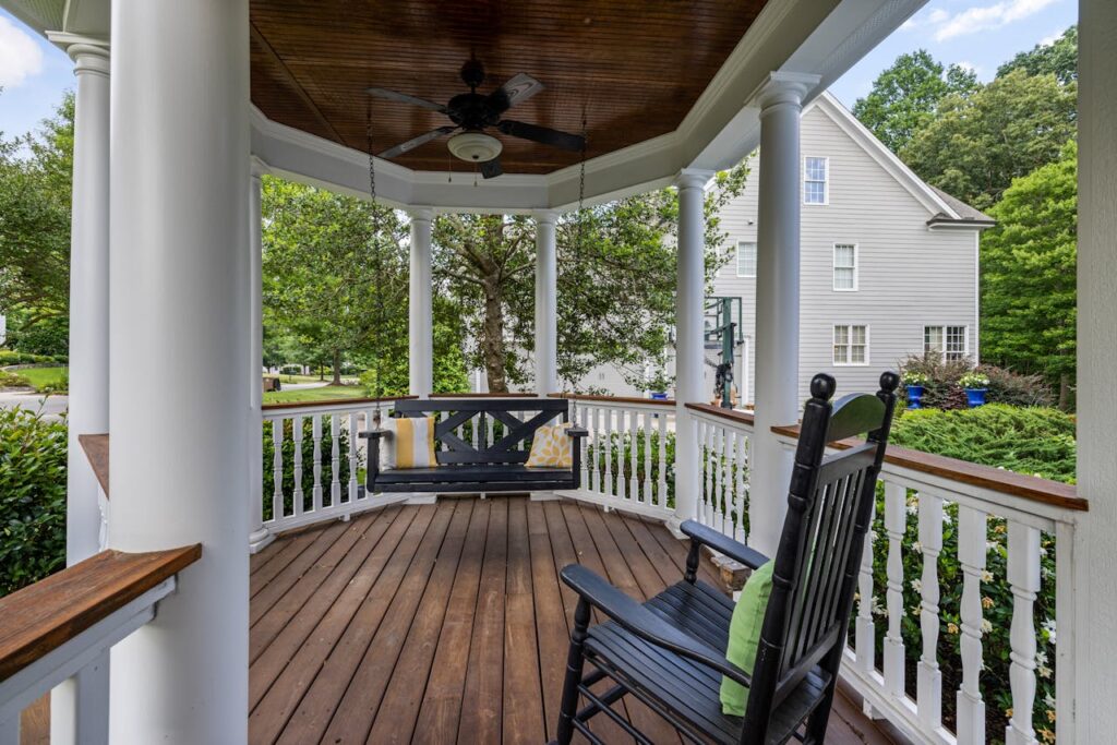 Covered front porch with stained wood decking and finished railing details