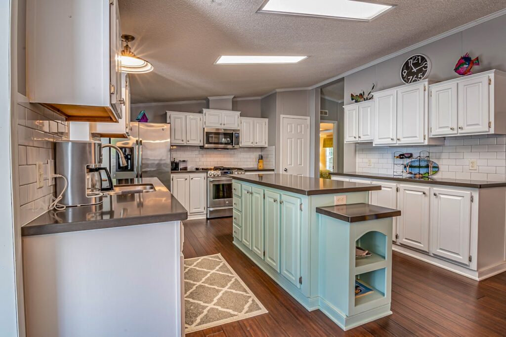 Renovated kitchen with white painted cabinets and light blue center island